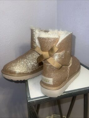 UGG Gold Mini Bailey Bow II Glitter Shearling Boots.